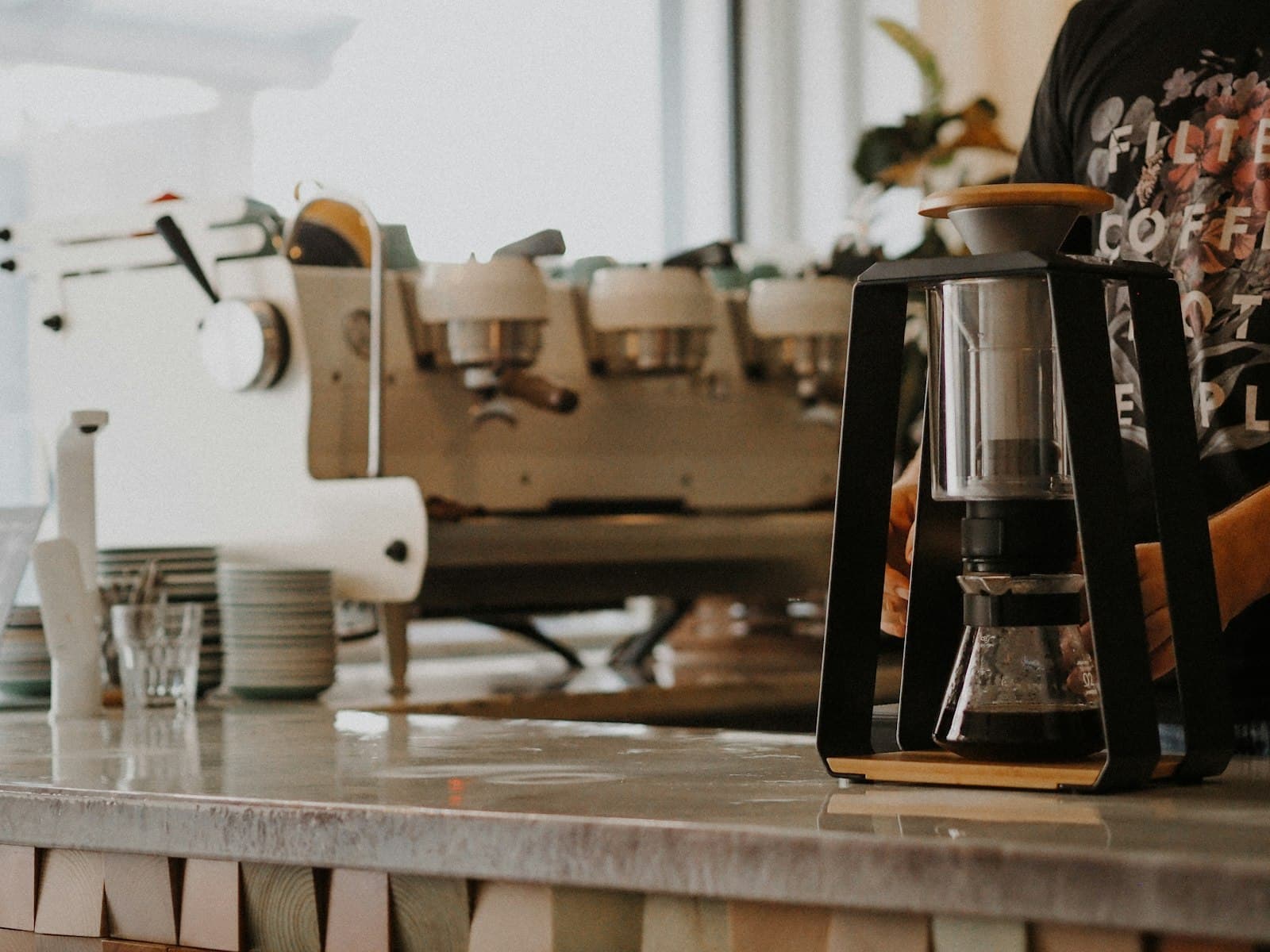 A white and silver drip coffee machine on a wooden table
