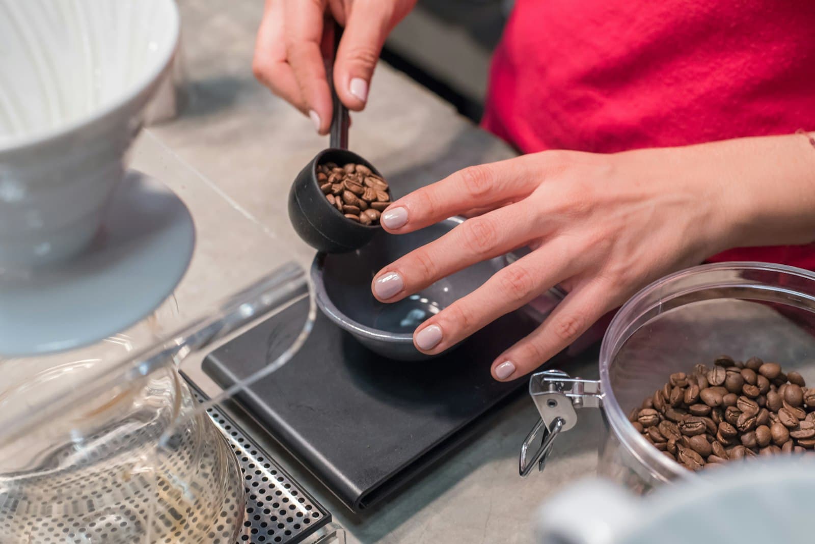 A person scooping and measuring whole coffee beans