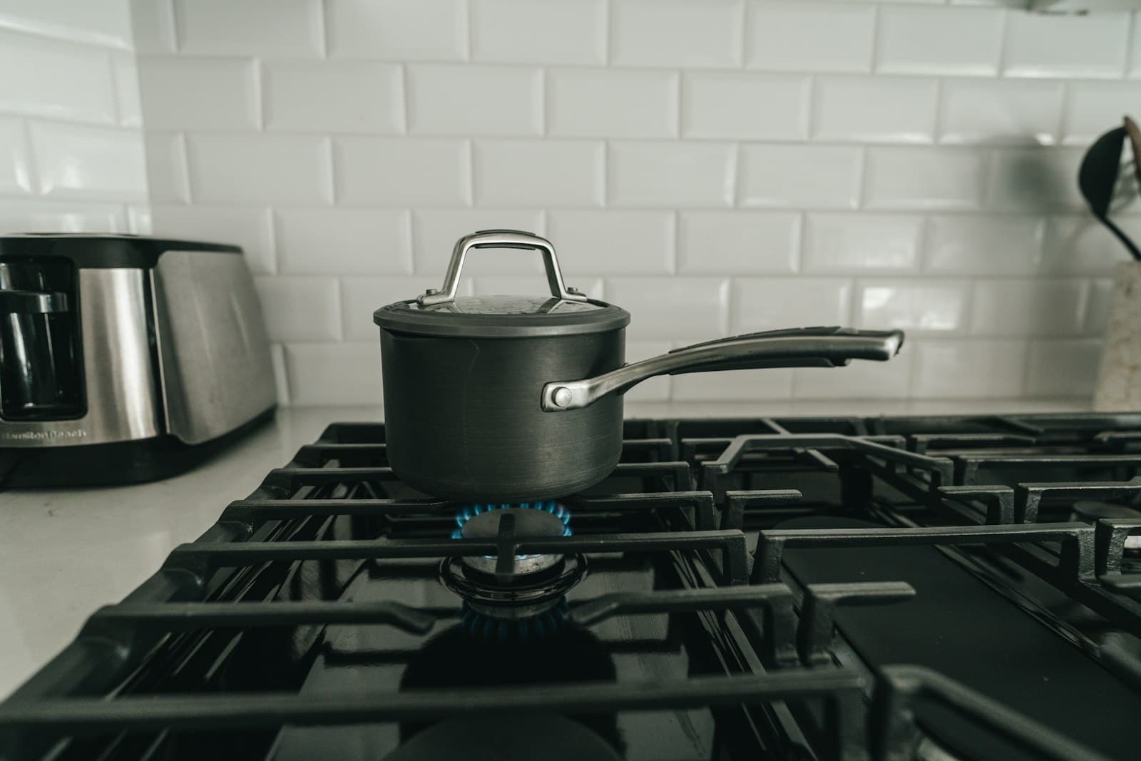 A stovetop moka pot brewing on a gas burner